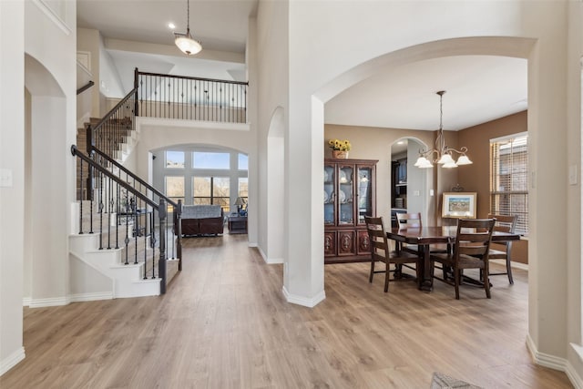 entrance foyer featuring hardwood / wood-style flooring, a chandelier, and a high ceiling