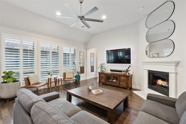 living room with ceiling fan, dark wood-type flooring, and lofted ceiling