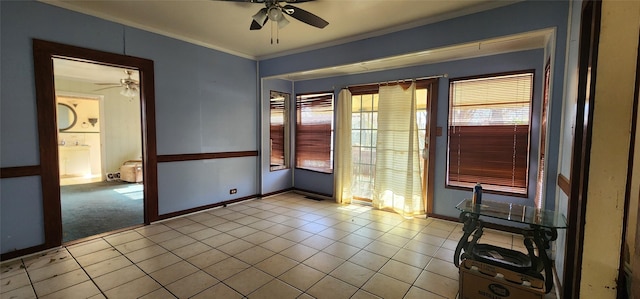 tiled empty room with ceiling fan and crown molding