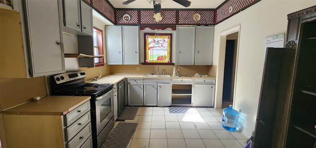 kitchen with black dishwasher, stainless steel electric range oven, light tile patterned floors, sink, and ceiling fan