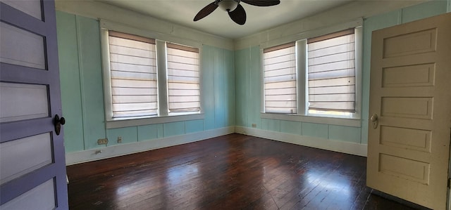 empty room with ceiling fan, a wealth of natural light, and dark hardwood / wood-style floors