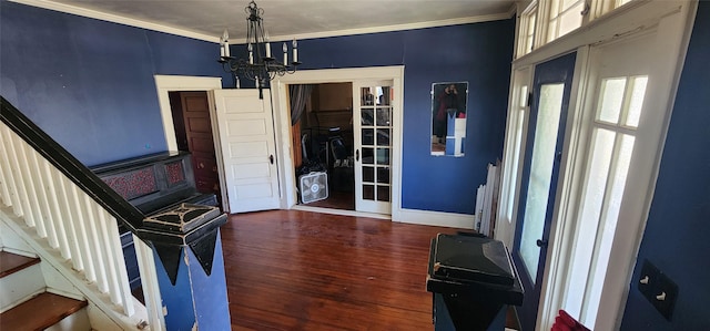 entryway with crown molding, an inviting chandelier, and dark hardwood / wood-style flooring