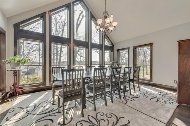 dining space featuring a healthy amount of sunlight, a chandelier, and high vaulted ceiling