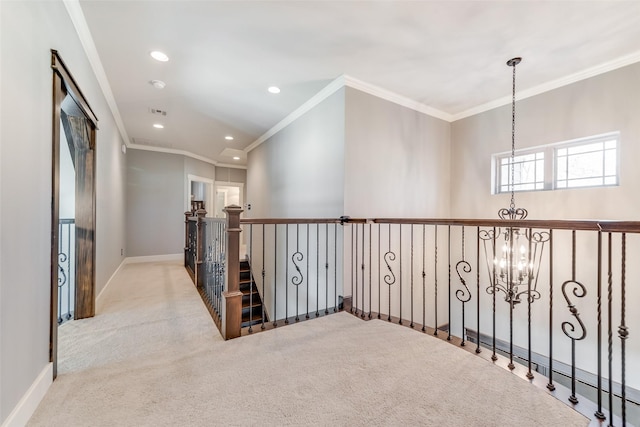 hall featuring light colored carpet, crown molding, and an inviting chandelier