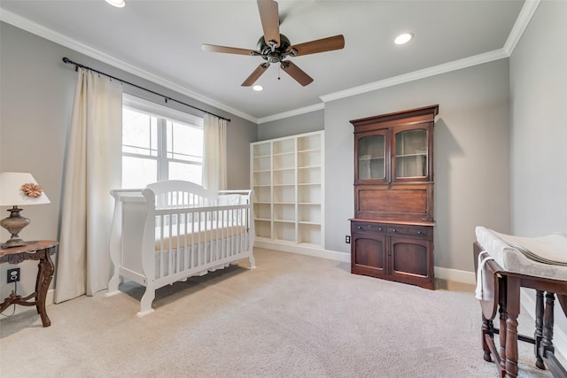 bedroom with ceiling fan, light carpet, ornamental molding, and a crib