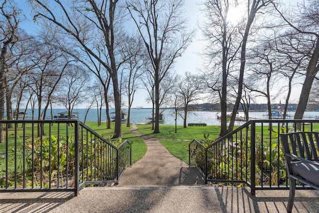 surrounding community featuring a lawn and a water view