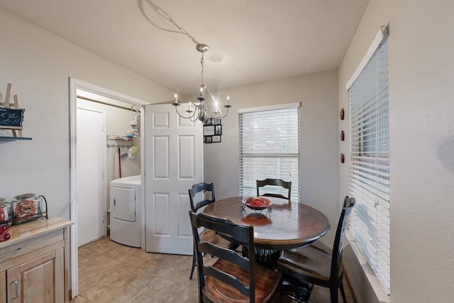 tiled dining area featuring washer / clothes dryer and an inviting chandelier