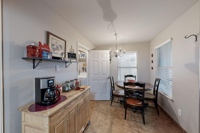 dining space with an inviting chandelier and washer / clothes dryer