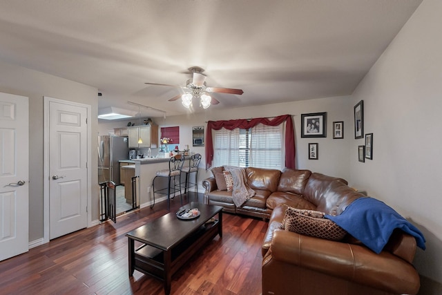 living room featuring dark wood-type flooring and ceiling fan