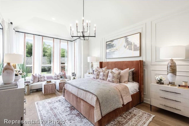 bedroom with light hardwood / wood-style flooring and a chandelier