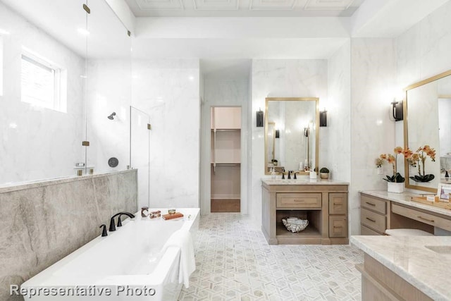 bathroom featuring tile walls, vanity, and a bathtub