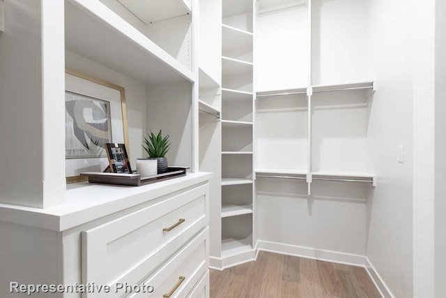 spacious closet featuring light hardwood / wood-style floors