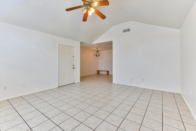 tiled spare room featuring vaulted ceiling and ceiling fan with notable chandelier