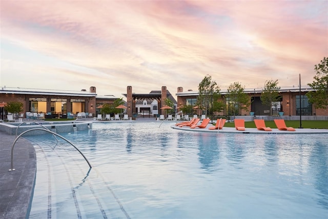 pool at dusk featuring a patio