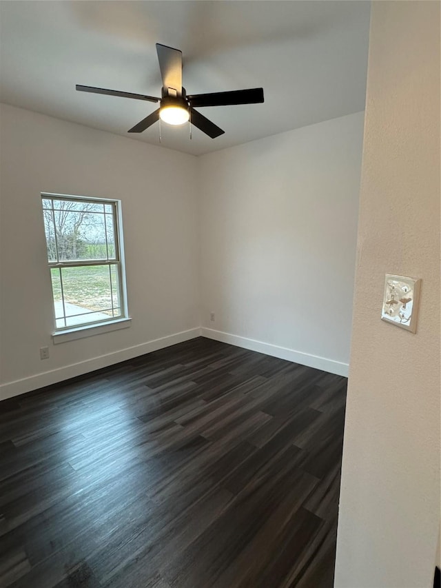 empty room with ceiling fan and dark hardwood / wood-style flooring