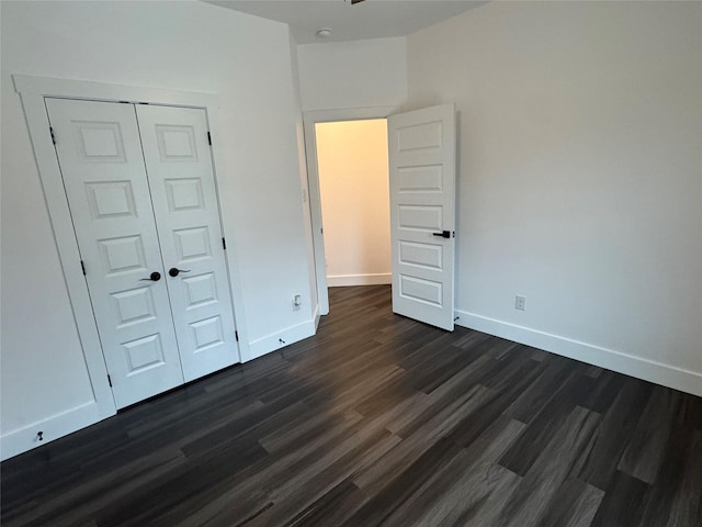 unfurnished bedroom featuring dark hardwood / wood-style flooring and a closet