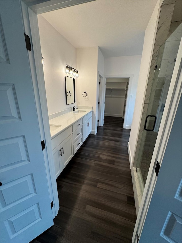 bathroom featuring walk in shower, vanity, and hardwood / wood-style flooring