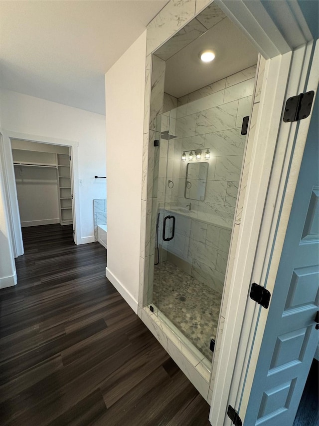 bathroom with a shower with shower door and wood-type flooring