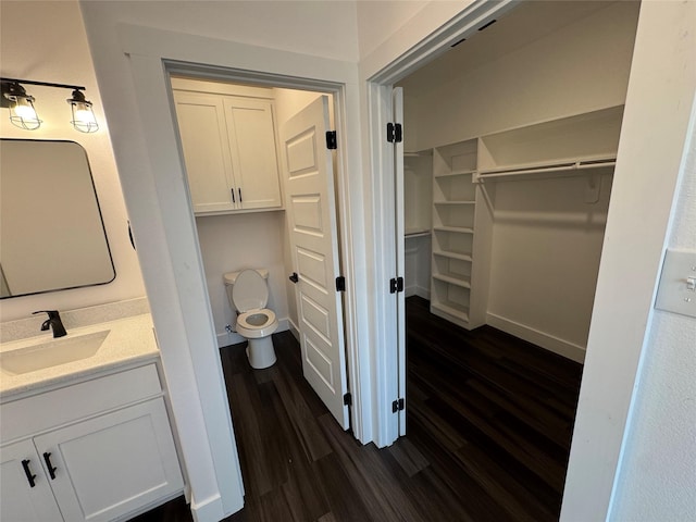 bathroom featuring vanity, hardwood / wood-style floors, and toilet