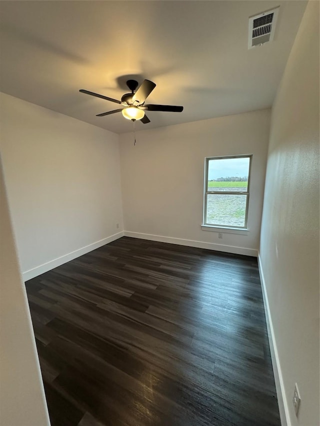 empty room featuring dark wood-type flooring and ceiling fan