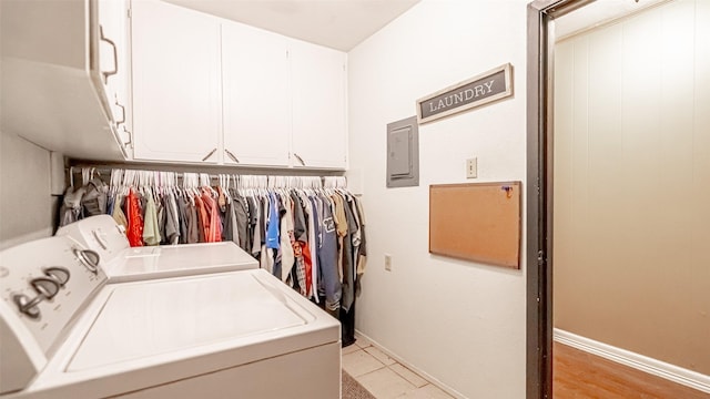 clothes washing area with light tile patterned floors, cabinets, and independent washer and dryer