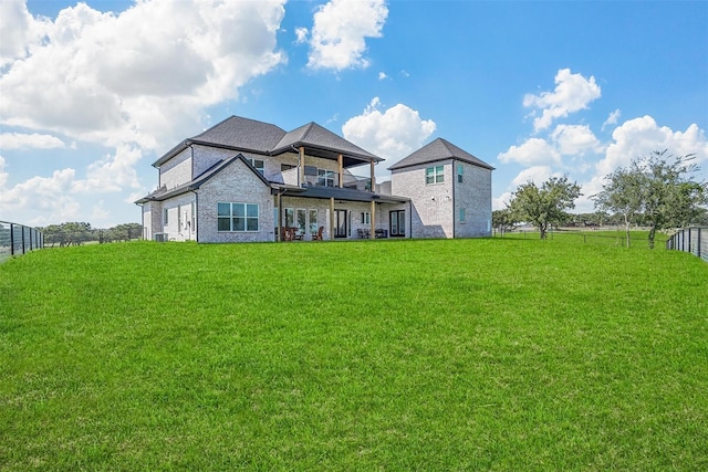 back of house featuring a balcony and a lawn