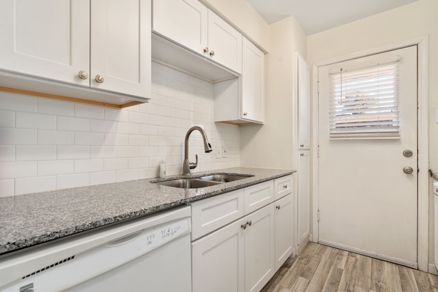 kitchen with sink, dishwasher, white cabinets, and decorative backsplash