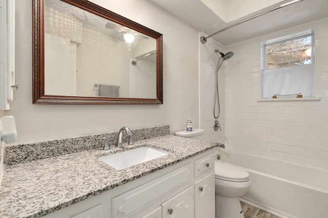 full bathroom with hardwood / wood-style floors, toilet, vanity, and tiled shower / bath