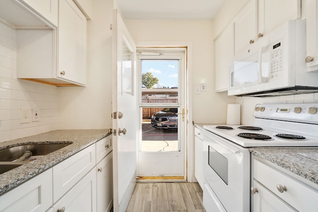 kitchen featuring white cabinets, white appliances, light stone countertops, and tasteful backsplash