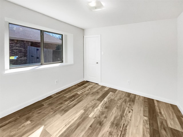 unfurnished room with wood-type flooring