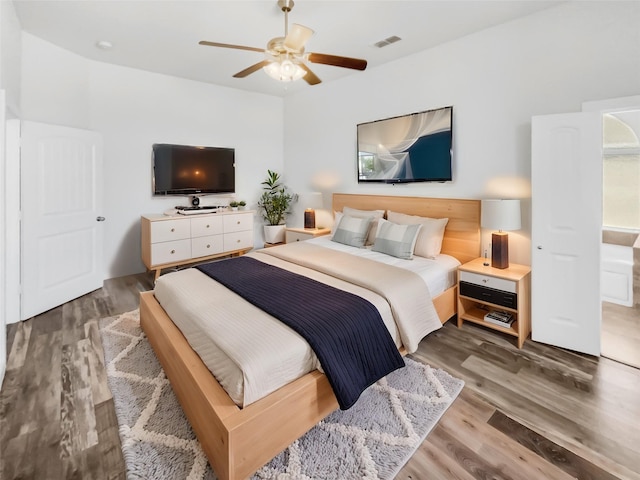 bedroom with ceiling fan, multiple windows, and hardwood / wood-style flooring