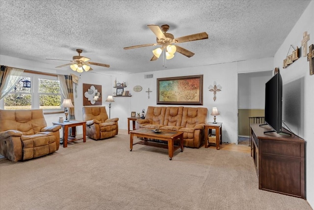 carpeted living room with ceiling fan and a textured ceiling