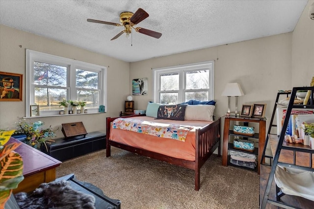 bedroom with ceiling fan, multiple windows, and a textured ceiling