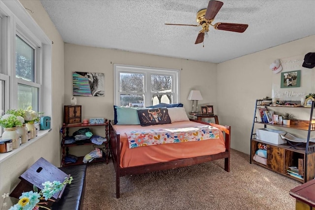 carpeted bedroom featuring ceiling fan and a textured ceiling