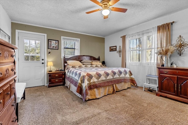 bedroom featuring ceiling fan, light colored carpet, and a textured ceiling