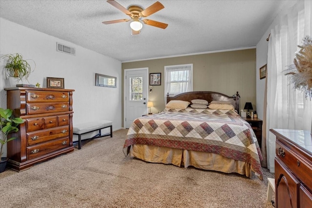 carpeted bedroom with a textured ceiling and ceiling fan