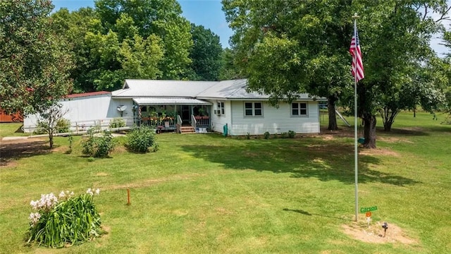 rear view of property featuring a porch and a yard