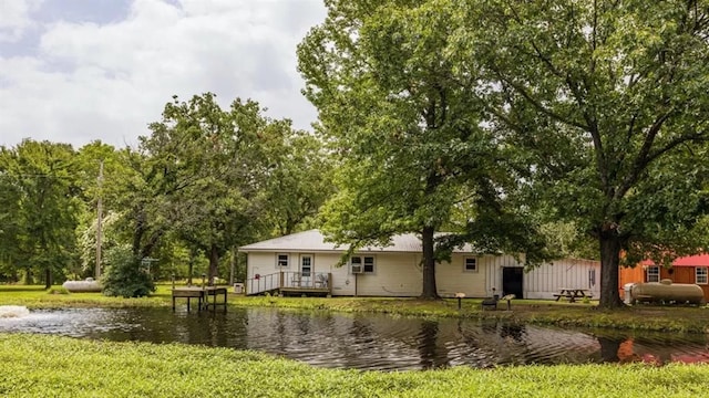 view of front of house featuring a front yard and a deck with water view