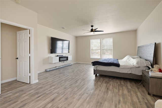 bedroom with light hardwood / wood-style floors and ceiling fan