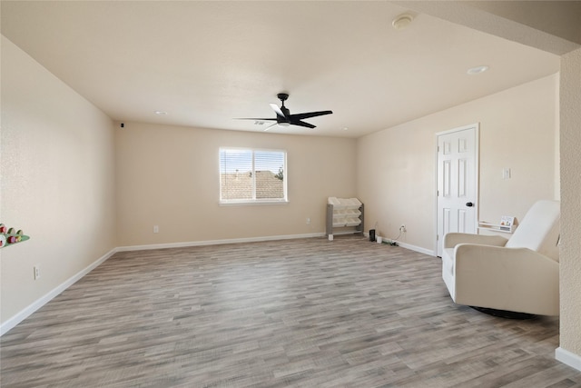 sitting room with light hardwood / wood-style floors and ceiling fan