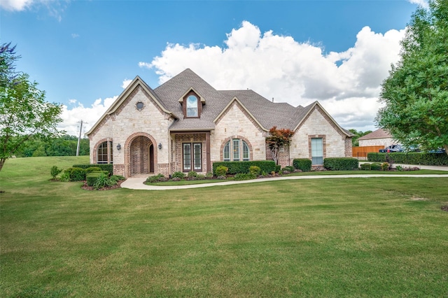 french country inspired facade with a front lawn