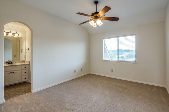 unfurnished room featuring sink, ceiling fan, vaulted ceiling, and light carpet