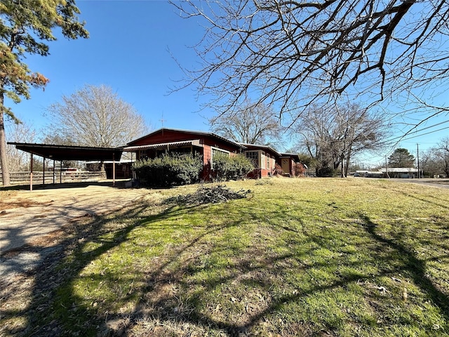 view of side of home featuring a yard and a carport