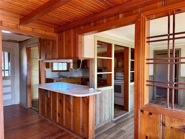 kitchen featuring beam ceiling, wood walls, dark hardwood / wood-style flooring, and white electric range