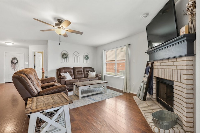 living room featuring a fireplace, dark wood-type flooring, and ceiling fan