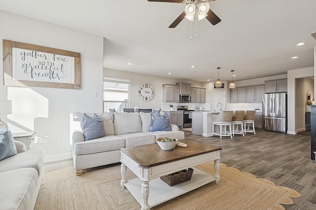 living room featuring recessed lighting, a ceiling fan, baseboards, and wood finished floors