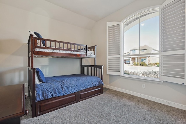 carpeted bedroom featuring baseboards and vaulted ceiling