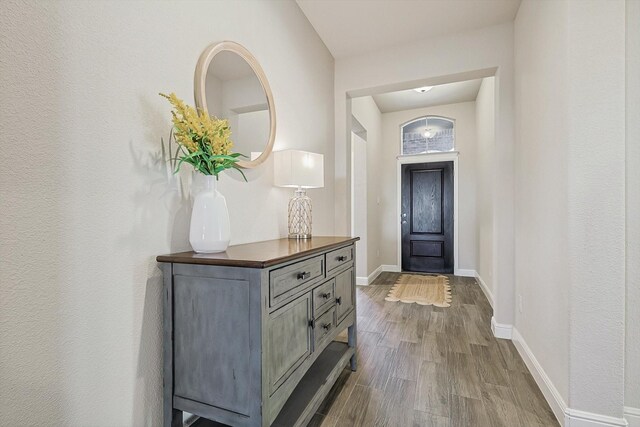 kitchen with sink, gray cabinetry, hanging light fixtures, a kitchen island with sink, and backsplash