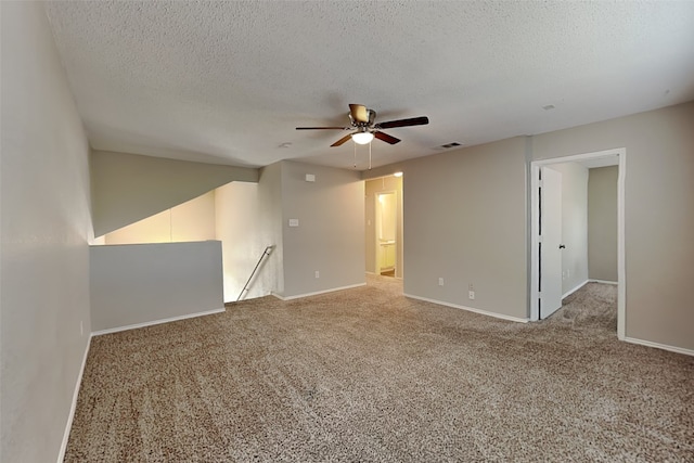 carpeted spare room with ceiling fan and a textured ceiling