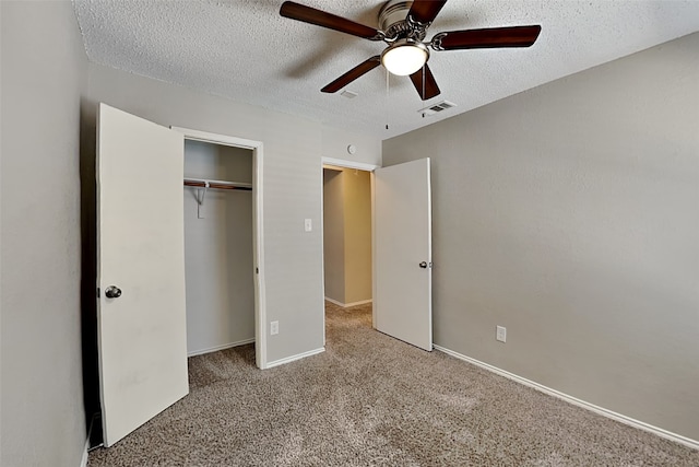 unfurnished bedroom featuring light carpet, a textured ceiling, a closet, and ceiling fan